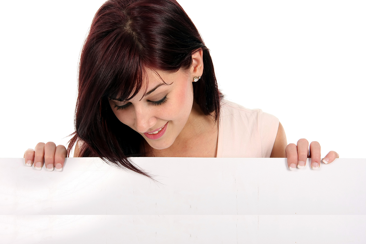 Gorgeous smiling brunette holding a white presentation board and looking down